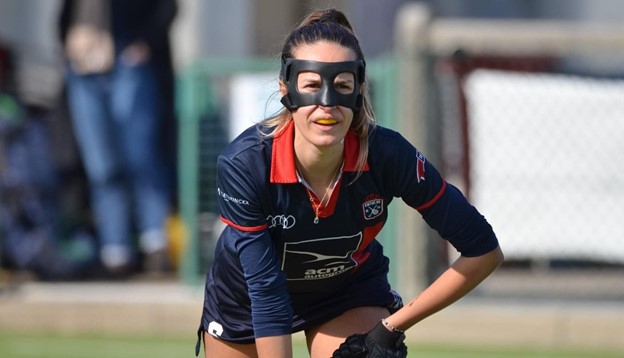 A field hockey player with black orthoses that protect part of the forehead and nose.